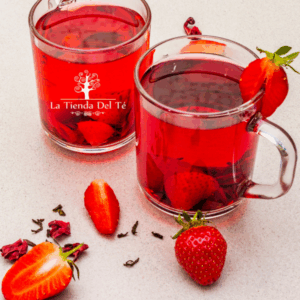 Trozos de frutas, fresas y frambuesas e infusión roja en tazas de cristal.
